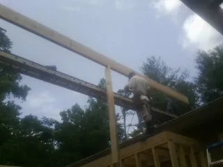 Carpenter setting a ridge beam over a new addition frame — Ice Dam Removal by Roofing Brothers in North Chelmsford
