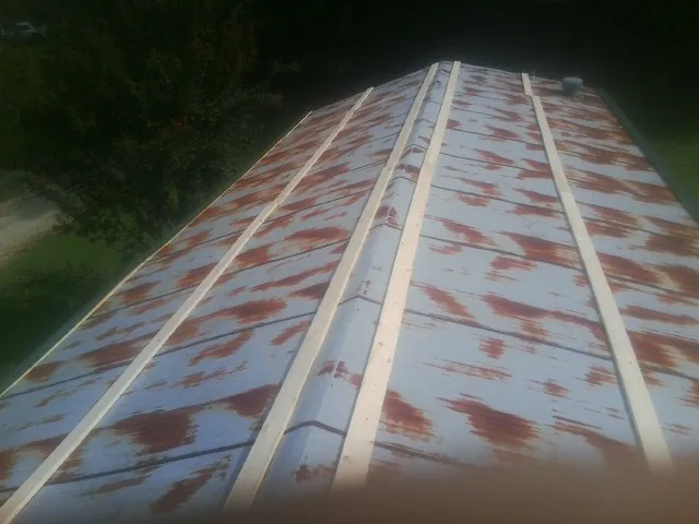 Rusted metal roof panels with new wood purlins before replacement — Storm Damage Roof Repair in North Chelmsford by Roofing Brothers