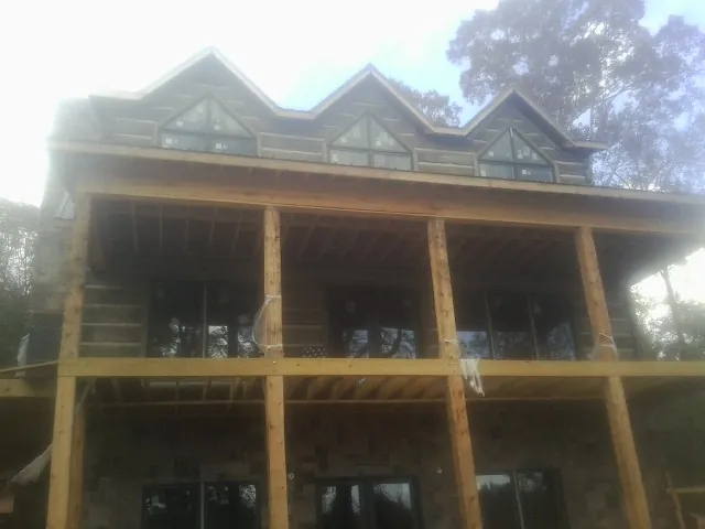 Dormers and porch framing on a large log home under construction — Roof Coating work by our crew in North Chelmsford