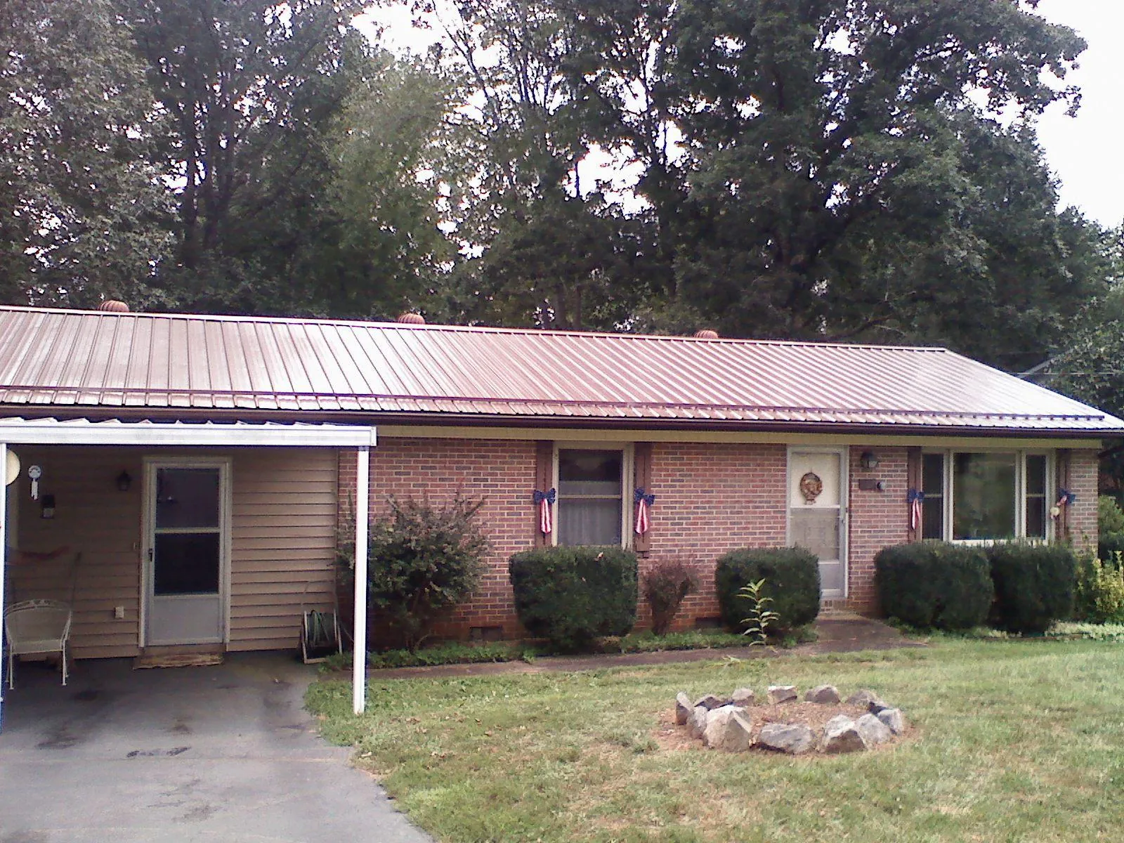 Bronze metal roof and carport on a brick ranch home — Roof Repair work by our crew in North Chelmsford